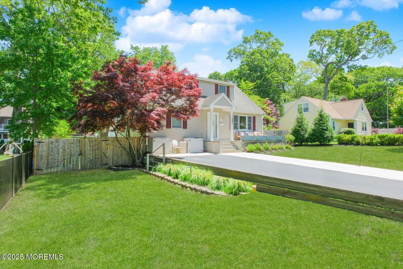 209 Woodcrest Road Oakhurst, NJ 07755 - Photo 4 of 45 a front view of a house with a yard table and chairs