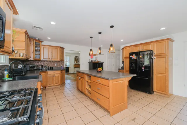 a large kitchen with stainless steel appliances granite countertop a stove and a refrigerator