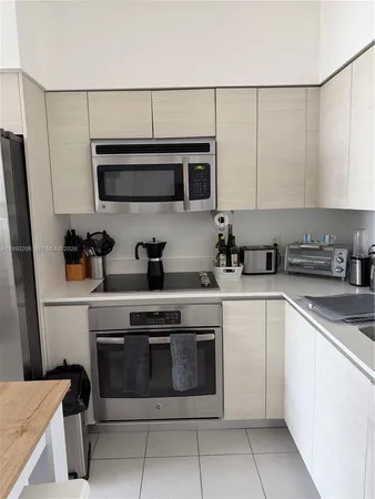 a kitchen with stainless steel appliances a stove a sink and a refrigerator