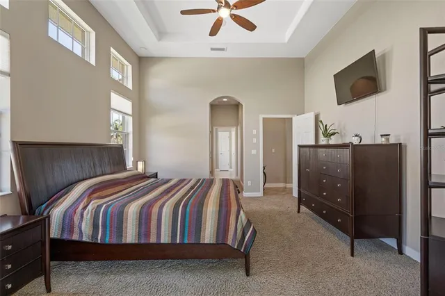 a bedroom with a bed and a flat tv screen on dresser