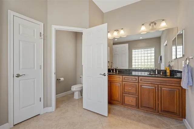 a large bathroom with a granite countertop sink a toilet and a bathtub
