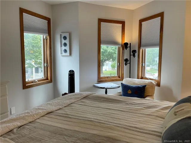 a bedroom with a bed and a large window