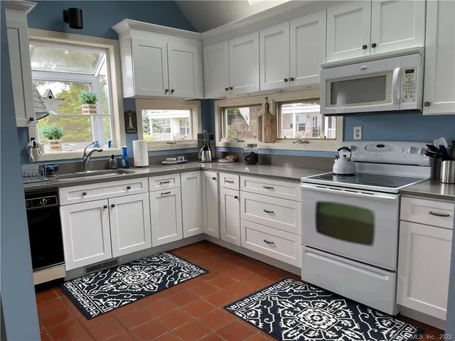a kitchen with stainless steel appliances a stove a sink and cabinets