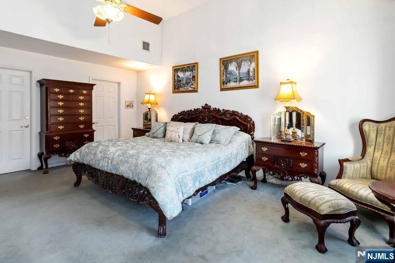 2 Upper Lake Road Oak Ridge, NJ 07438 - Photo 26 of 50 a bedroom with a bed and a chandelier