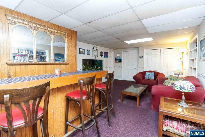 2 Upper Lake Road Oak Ridge, NJ 07438 - Photo 37 of 50 a living room with furniture a flat screen tv and kitchen view