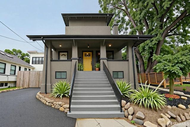 a front view of a house with a tree