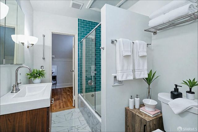 a bathroom with a sink a faucet a potted plant and a bathtub