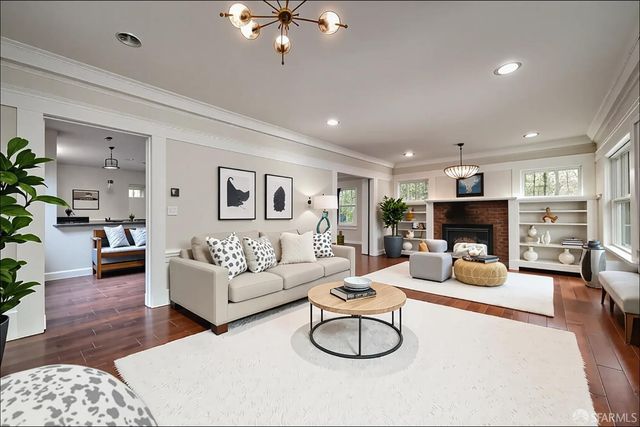 a living room with furniture a fireplace and wooden floor