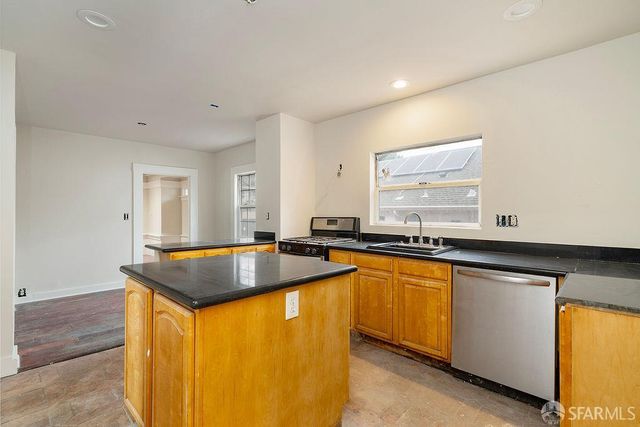 a kitchen with granite countertop sink stove and cabinets