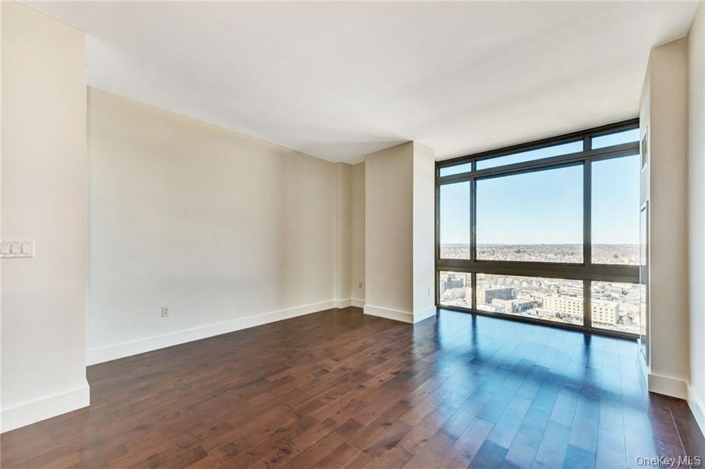 175 Huguenot Street, Unit 2404 New Rochelle, NY 10801 - Photo 4 of 8 Living room with a wall of windows and dark wood finished floors