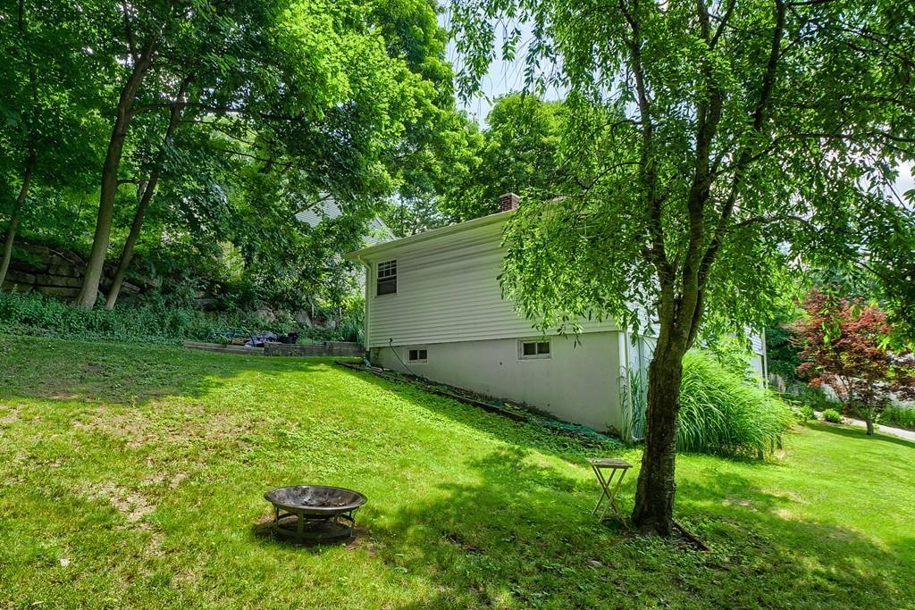 54 Manhattan Road Worcester, MA 01602 - Photo 18 of 19 a backyard of a house with plants and large trees