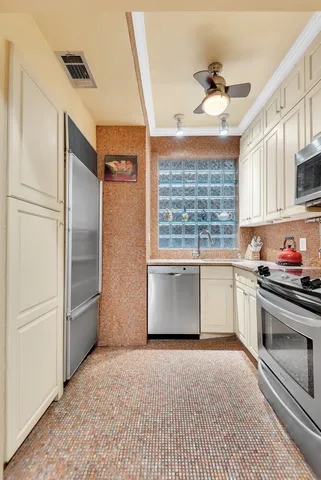 a kitchen with stainless steel appliances granite countertop a refrigerator a sink and white cabinets