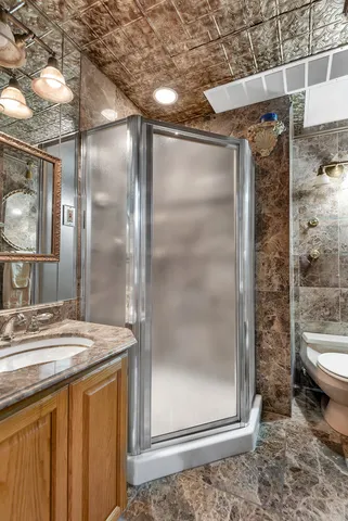 a bathroom with a granite countertop sink mirror and toilet