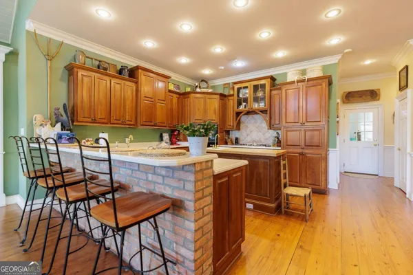 a kitchen with kitchen island granite countertop a sink window and cabinets
