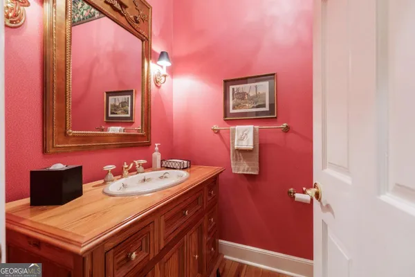 a en suite bathroom with a granite countertop sink a large mirror a vanity and a bathtub