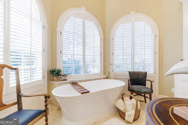 a bedroom with a bed and large windows