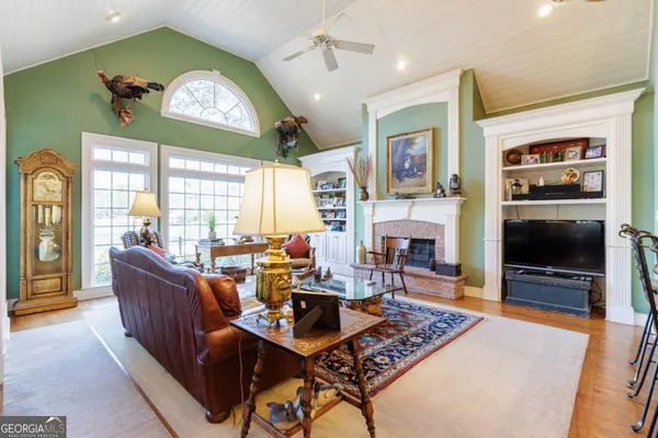 a living room with furniture a fireplace and a flat screen tv