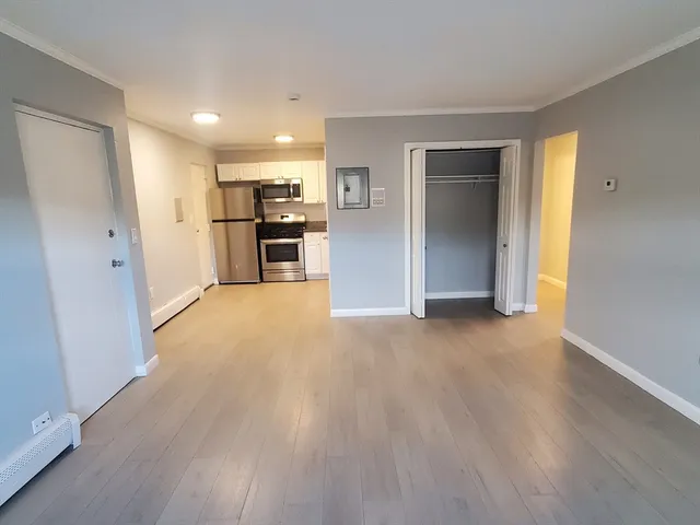 a view of a kitchen with a sink and a refrigerator