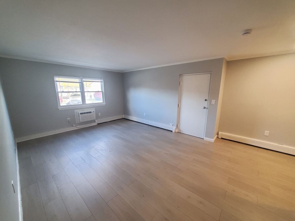215 Pearl Street, Unit 8 Stoughton, MA 02072 - Photo 5 of 18 an empty room with wooden floor and windows