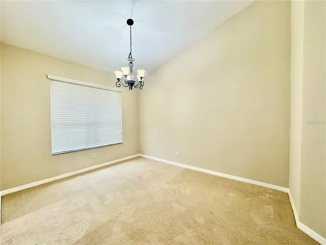 a view of a room with a chandelier fan and table