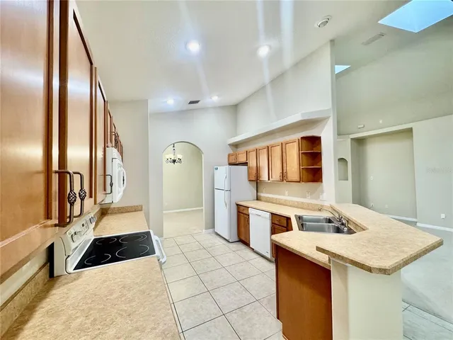 a kitchen with granite countertop a sink stove and refrigerator