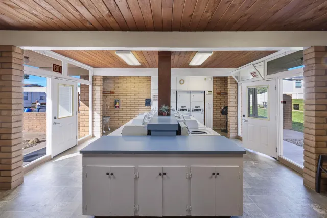 a view of kitchen island with stainless steel appliances granite countertop refrigerator sink and wooden cabinets