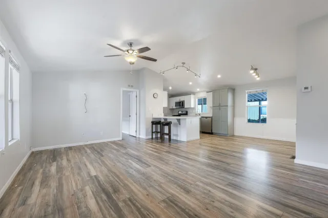 a view of empty room with wooden floor and ceiling fan