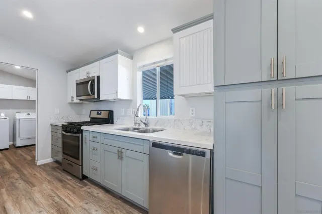 a kitchen with stainless steel appliances granite countertop a sink stove and refrigerator