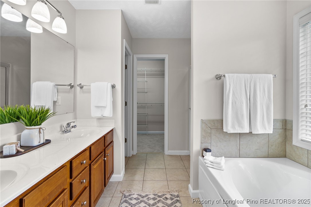 43 Ambrose Point Cameron, NC 28326 - Photo 29 of 45 a spacious bathroom with a double vanity sink a mirror and a bathtub