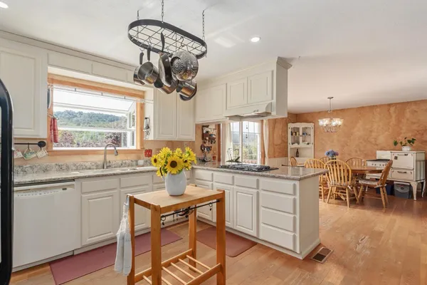 a kitchen with stainless steel appliances granite countertop cabinets and a dining table