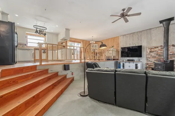 a living room with furniture a flat screen tv and a kitchen view