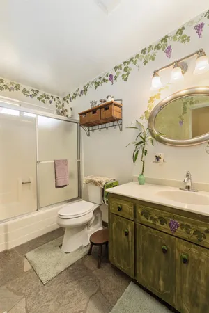 a bathroom with a granite countertop toilet sink and mirror