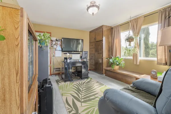 a living room with furniture a flat screen tv and a large window