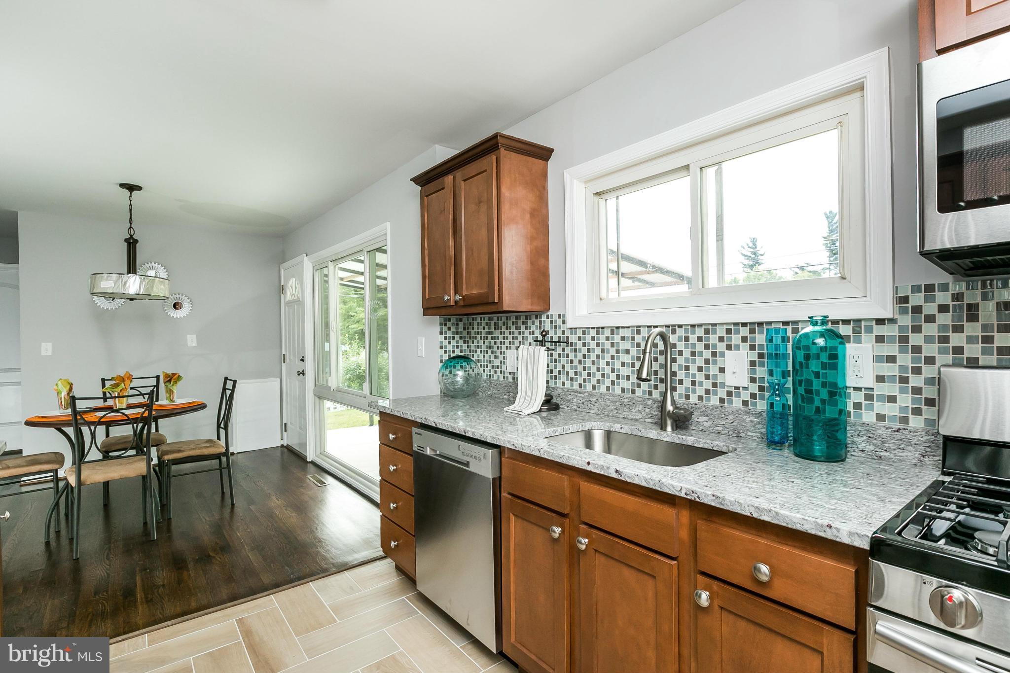 1015 Marksworth Road Catonsville, MD 21228 - Photo 5 of 13 a kitchen with stainless steel appliances granite countertop a stove a sink and a microwave