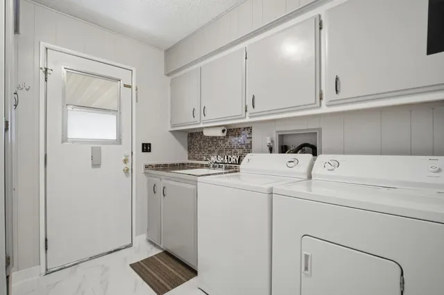 a view of washer and dryer with white cabinets