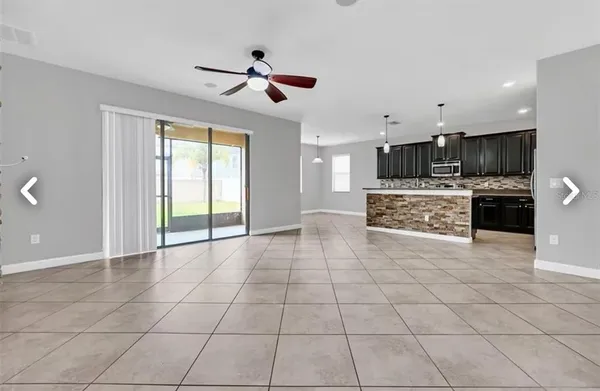 a view of a kitchen with furniture a ceiling fan and window