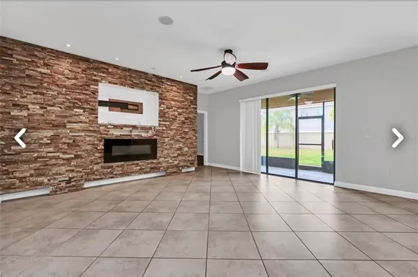 a view of an empty room with a fireplace and a window