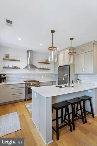a kitchen with a sink a stove and chairs