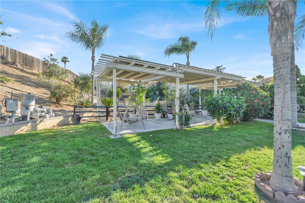 3350 May Court Riverside, CA 92503 - Photo 47 of 55 a view of a patio with table and chairs under an umbrella with palm trees