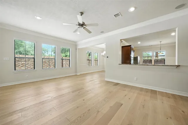 a view of an empty room with a window and wooden floor