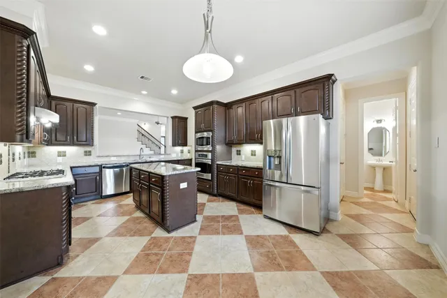 a kitchen with stainless steel appliances kitchen island granite countertop a refrigerator and stove