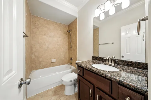 a bathroom with a granite countertop sink a toilet and bathtub