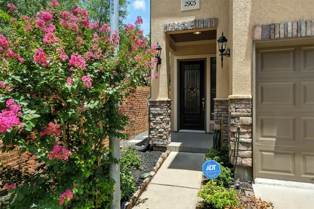 a front view of a house with a flower garden