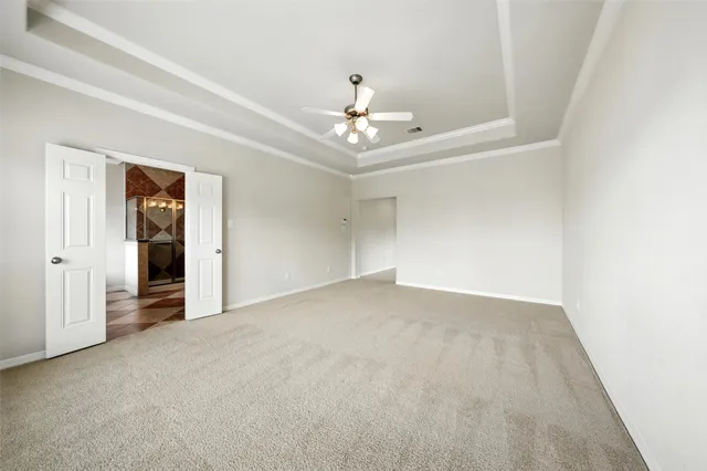 an empty room with chandelier fan and closet area