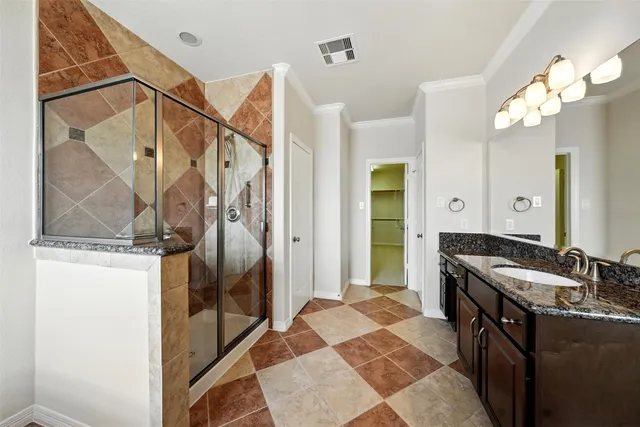 a bathroom with a granite countertop shower a mirror and a sink