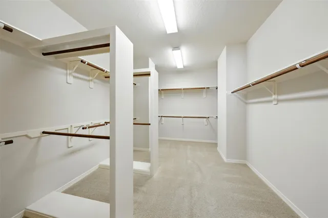 a view of walk in closet with empty racks