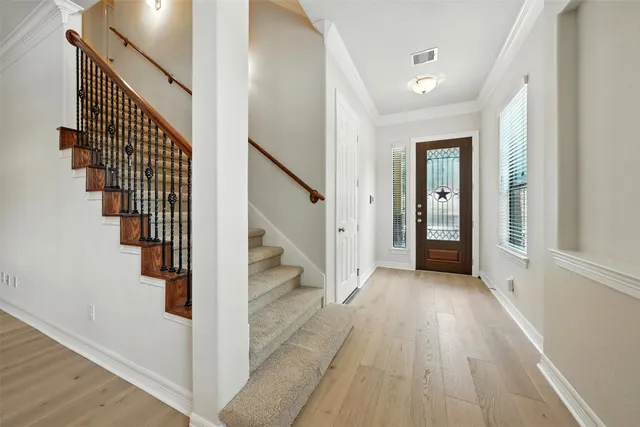 a view of a hallway with wooden floor and entryway