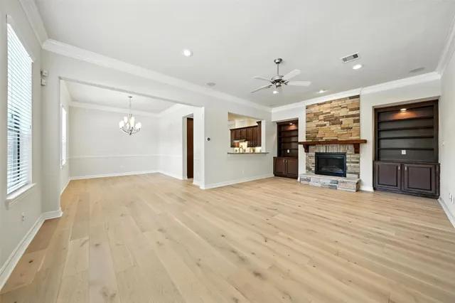 a view of an empty room with a fireplace cabinet and a window
