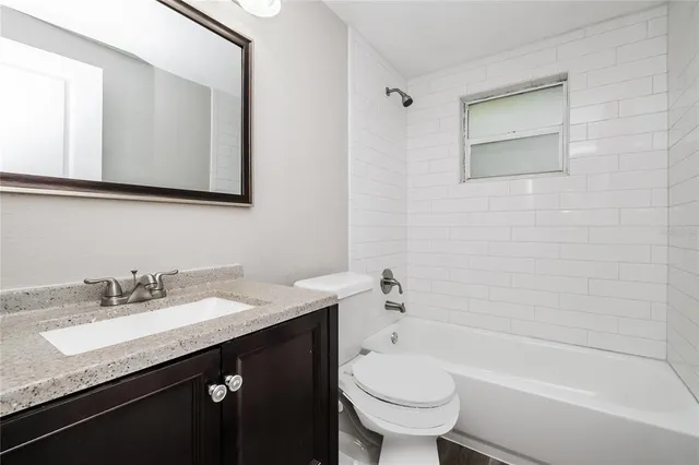a bathroom with a granite countertop sink toilet and mirror