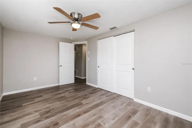 a view of an empty room with wooden floor